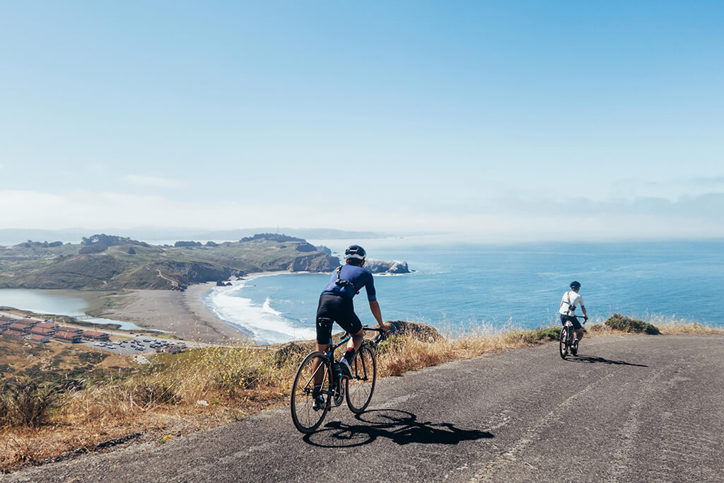 Group cycling overlooking ocean